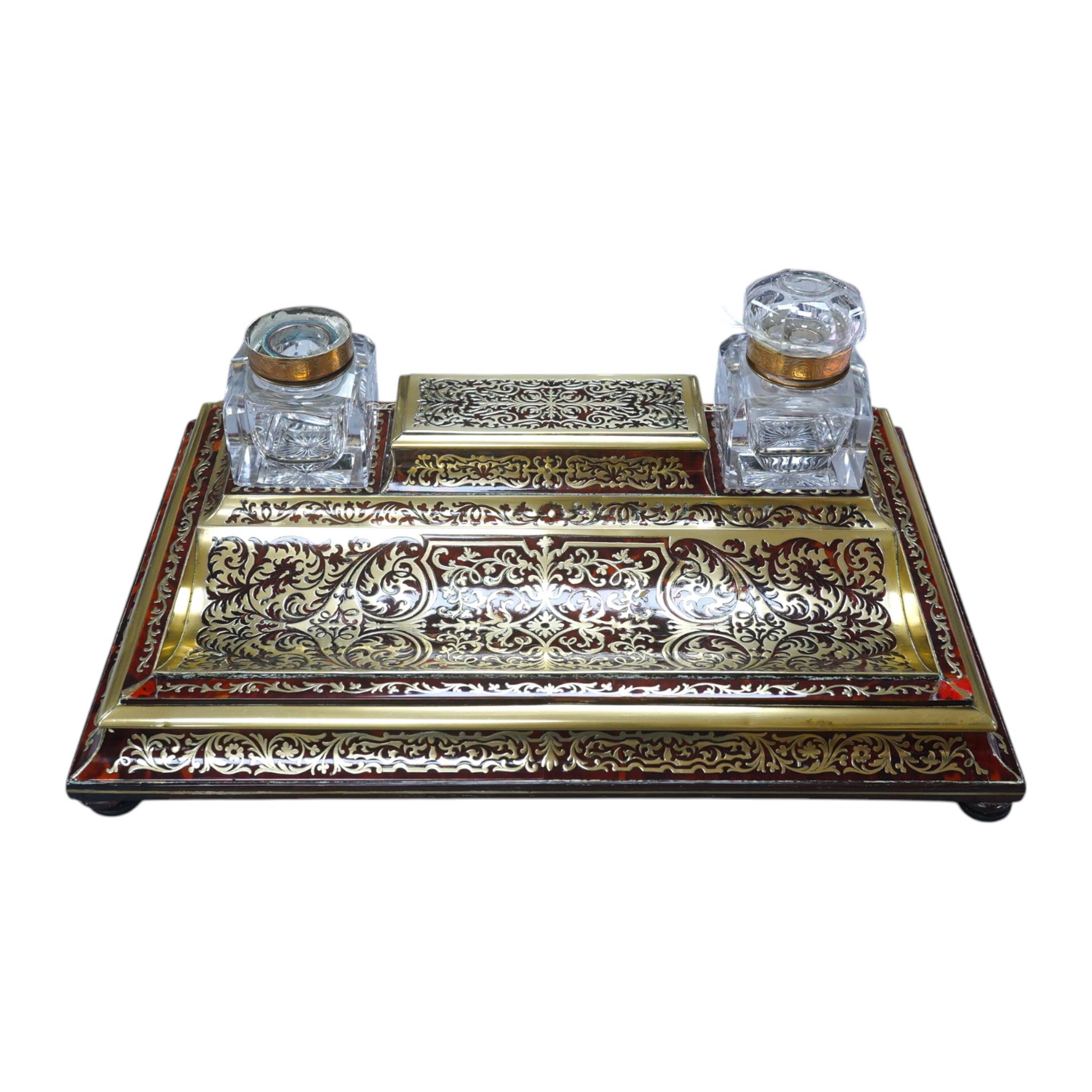 A French scarlet boullework double inkstand with original glass ink bottles c.1850, 39cm wide. Condition - inkstand good, one inkwell cover missing